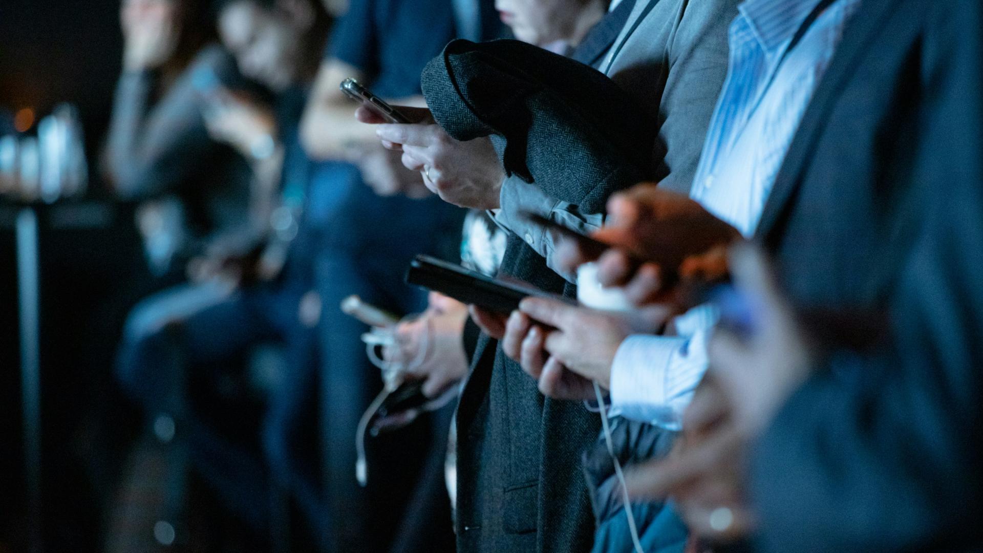 Menschen in einer Reihe mit Smartphone in der Hand